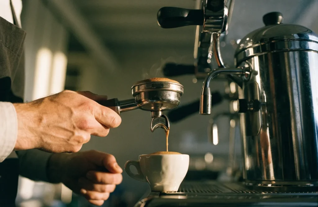 Un espresso saliendo de la máquina con la luz de la mañana entrando de lado